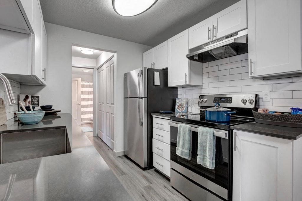 a kitchen with a stove top oven next to a refrigerator