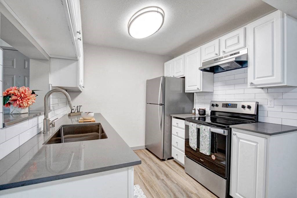 a kitchen with a sink stove and refrigerator