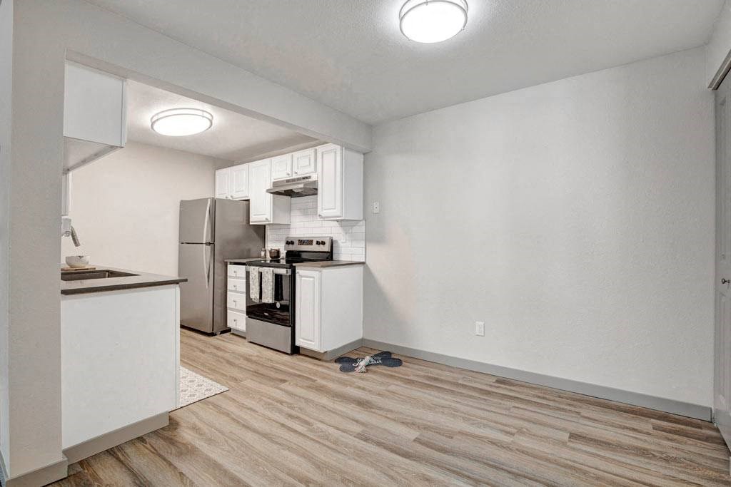 a kitchen with a stove top oven next to a refrigerator
