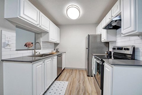 a kitchen with white cabinets and a stainless steel refrigerator
