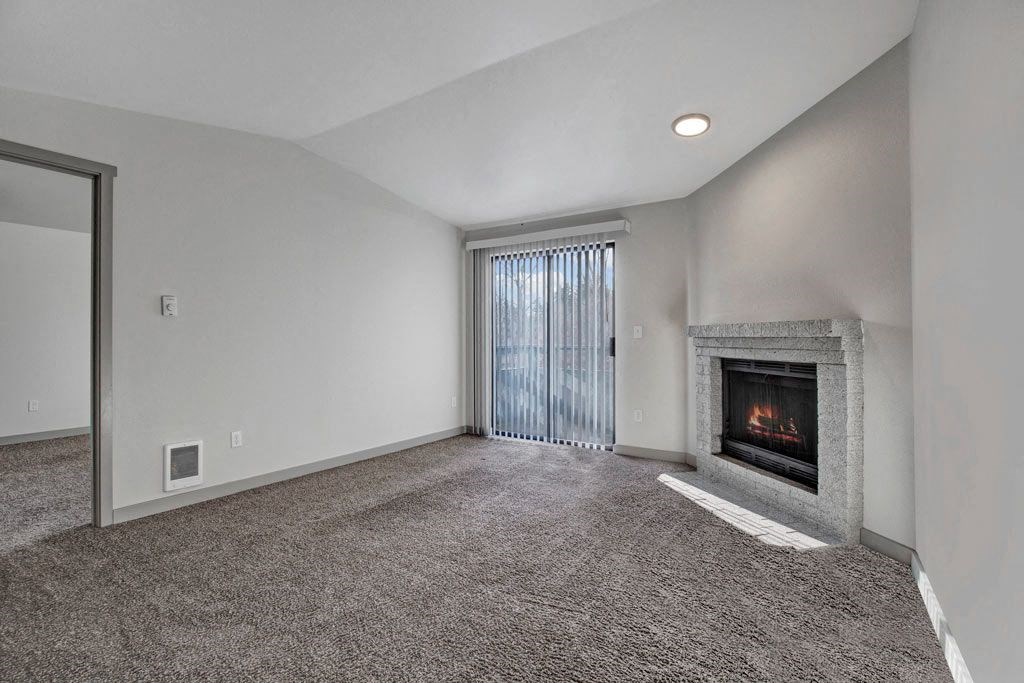 a living room with a fireplace and a sliding glass door