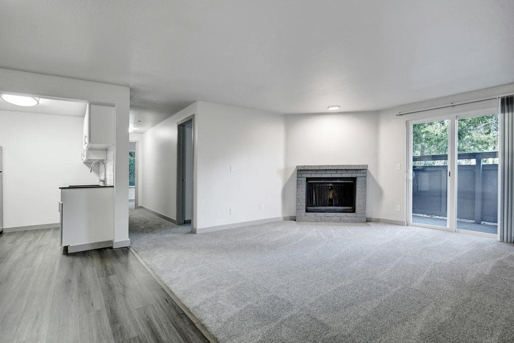 a living room with a fireplace and a kitchen