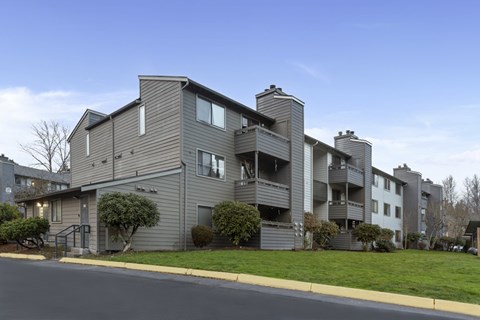 Apartment building with grey siding and multiple balconies.
