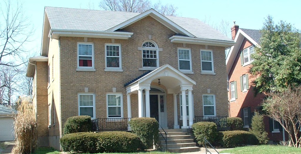 a brick house with a front porch and stairs