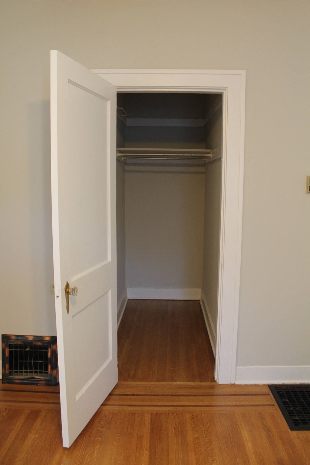 a room with an open closet door and a wood floor