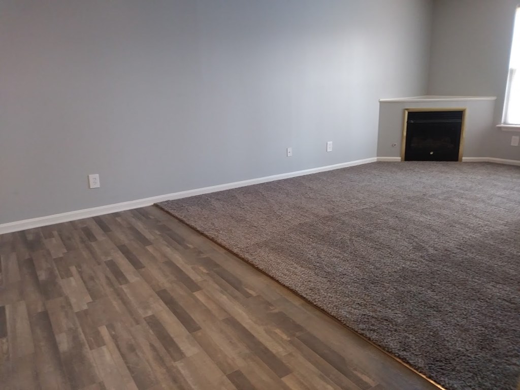 a living room with a rug and a fireplace
