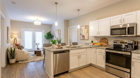 A modern kitchen with white cabinets and stainless steel appliances.