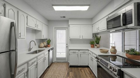 A kitchen with white cabinets and appliances.