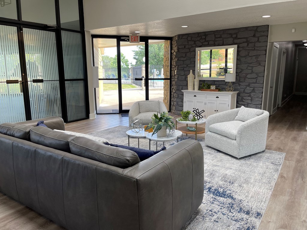 a living room with leather furniture and a stone wall