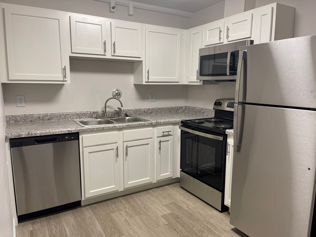a kitchen with white cabinets and stainless steel appliances