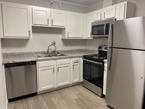 a kitchen with stainless steel appliances and white cabinets