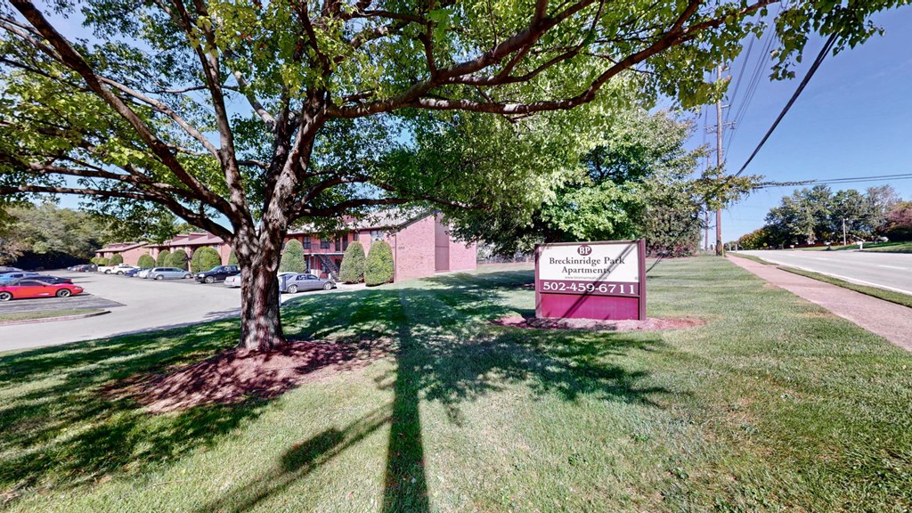 our sign is in the shade of a tree in front of our building