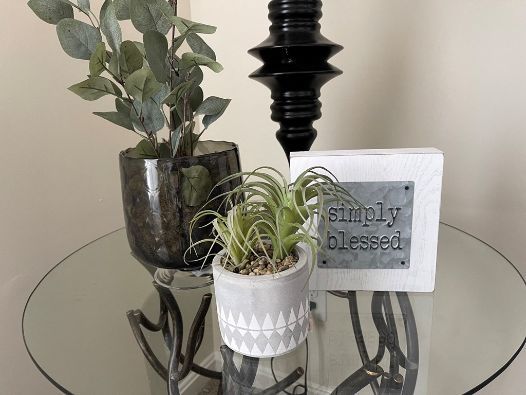 a glass table with plants and a sign that says simply blessed