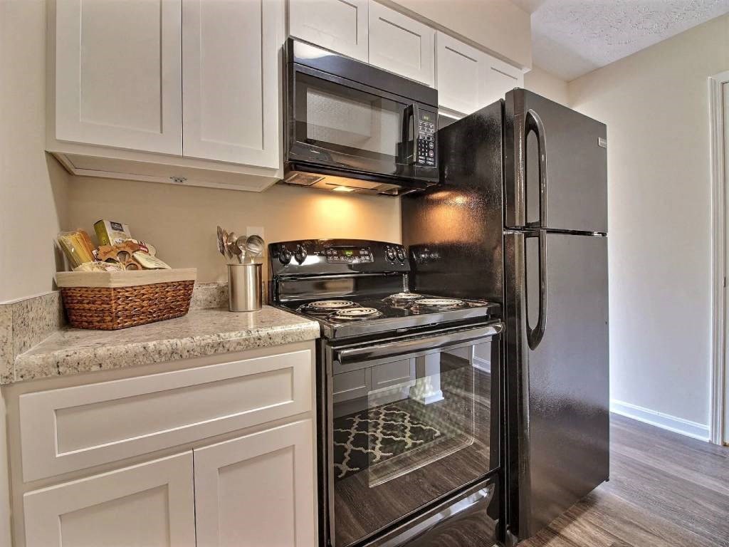 a kitchen with a stove refrigerator and microwave