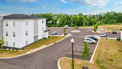 a white building with cars parked in a parking lot