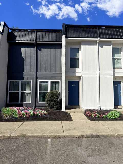 A modern two-story building with a blue door and windows.