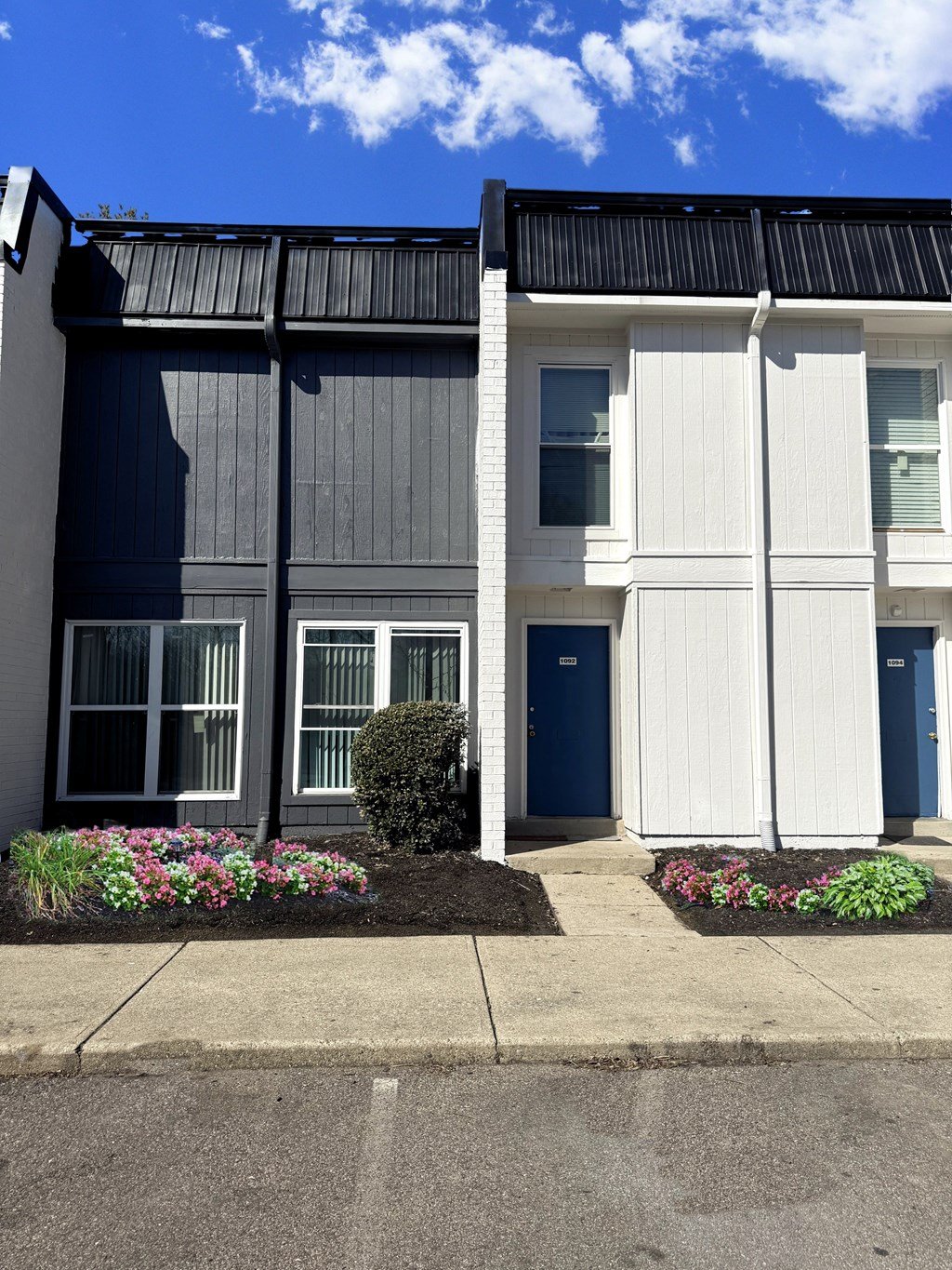 A modern two-story building with a blue door and windows.