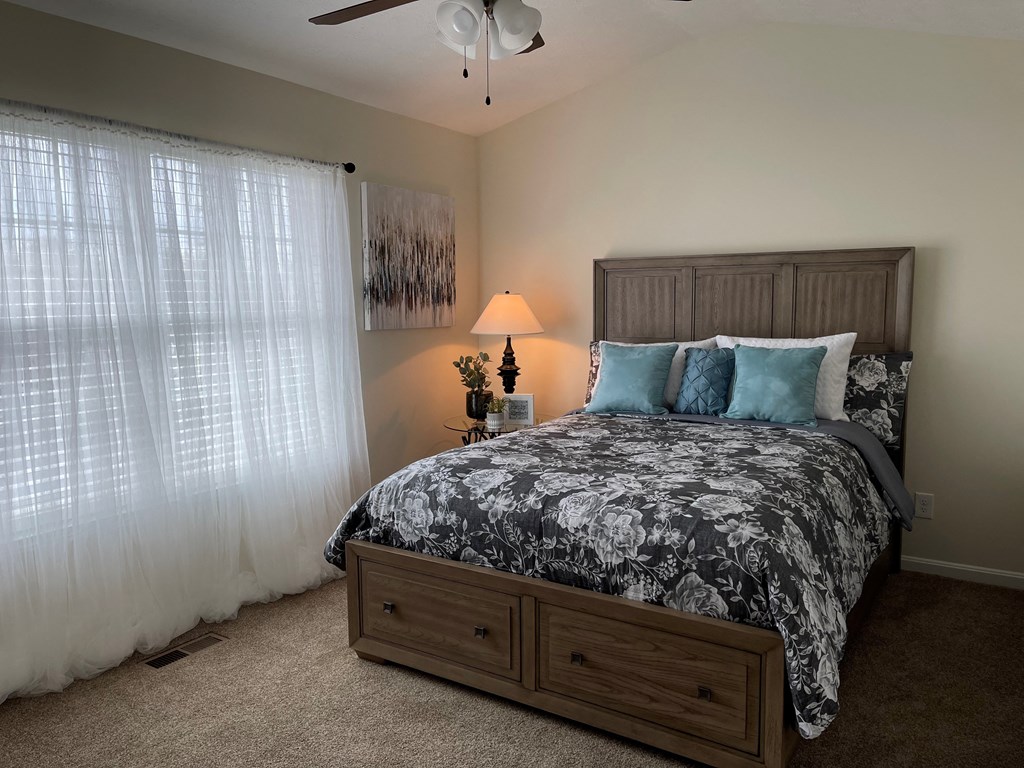 a bedroom with a bed and a window with curtains
