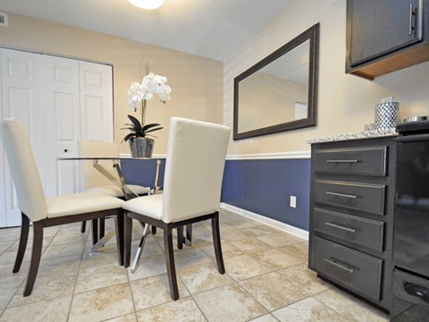 A kitchen with a table and chairs.