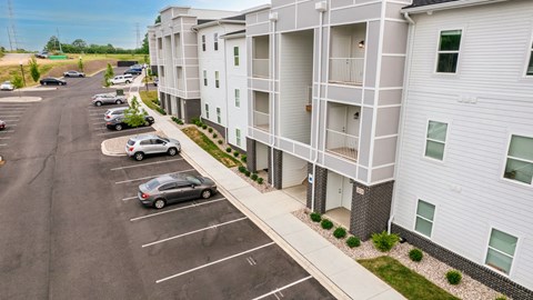 an aerial view of an apartment building with cars parked in a parking lot