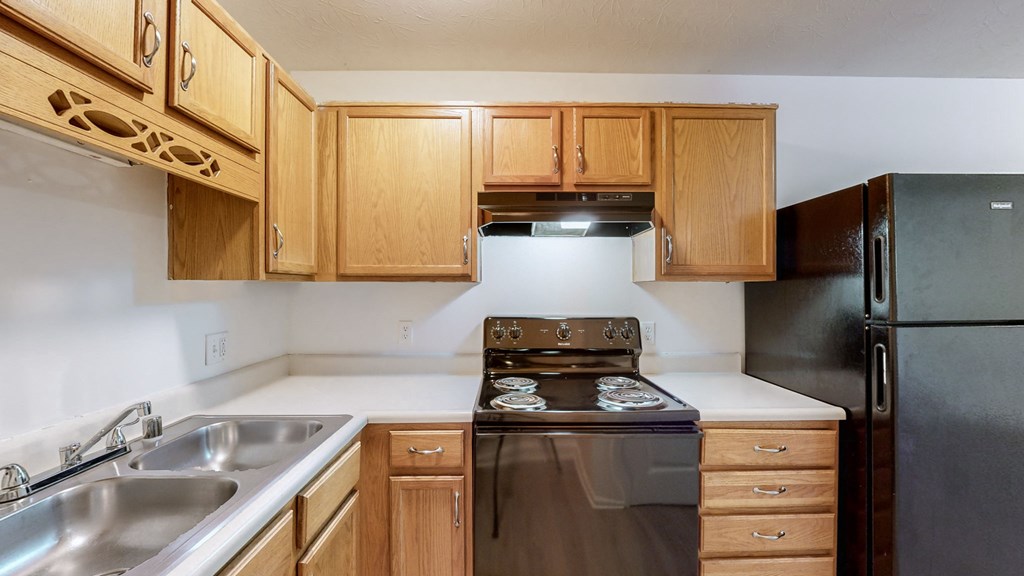 a kitchen with wooden cabinets and a stove and a sink