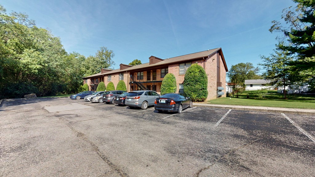 a parking lot with cars in front of a brick building