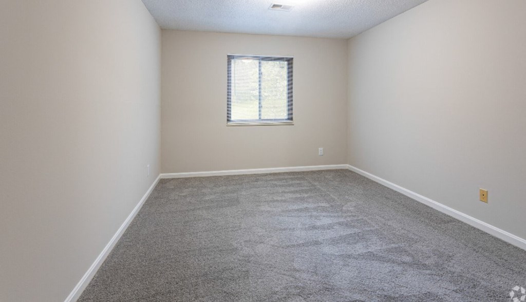an empty room with carpet and a window