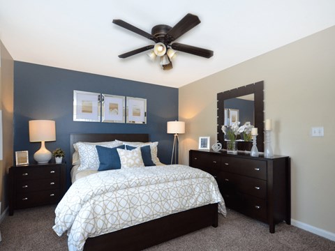 a bedroom with a bed and a ceiling fan