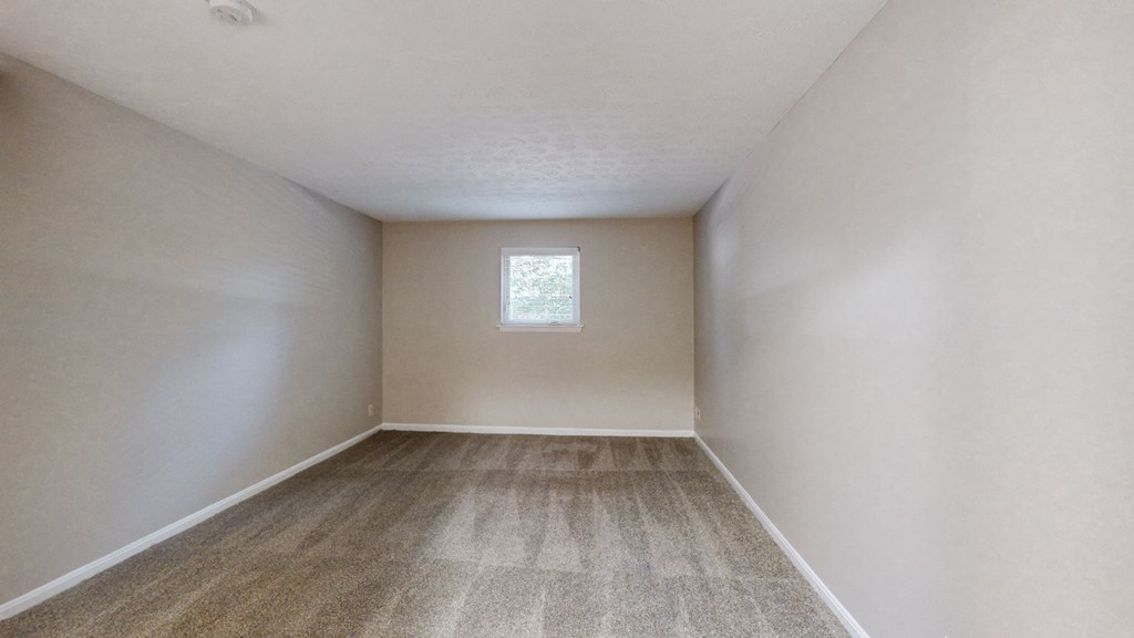 an empty room with white walls and a window