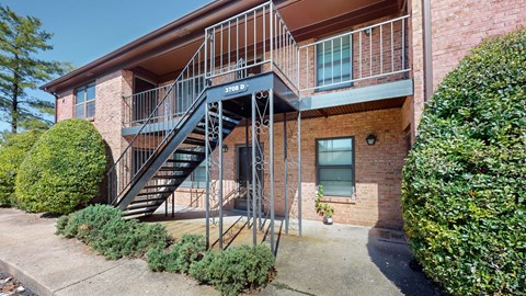 an apartment building with stairs and a balcony