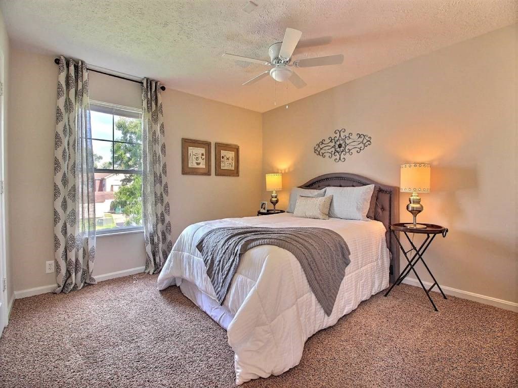 a bedroom with a bed and a ceiling fan