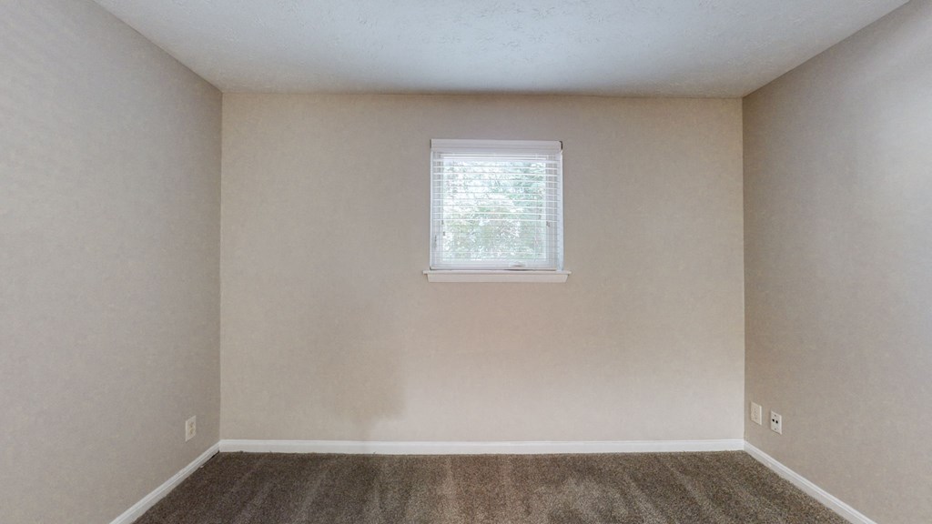 an empty room with white walls and a window