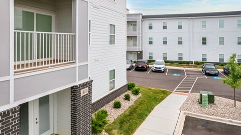 an apartment building with cars parked in a parking lot