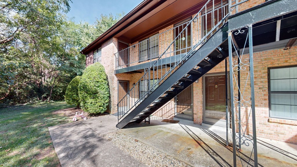 a balcony on the side of a building with a black staircase