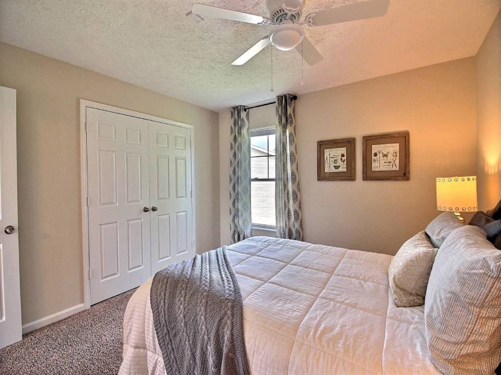 a bedroom with a large bed and a ceiling fan