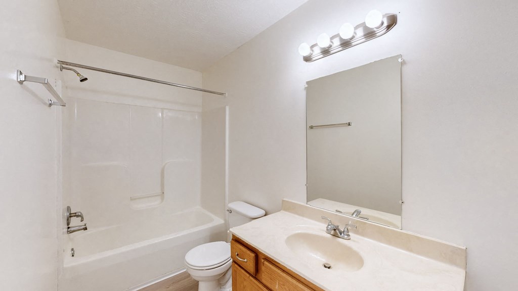 a bathroom with a sink toilet and shower and a mirror
