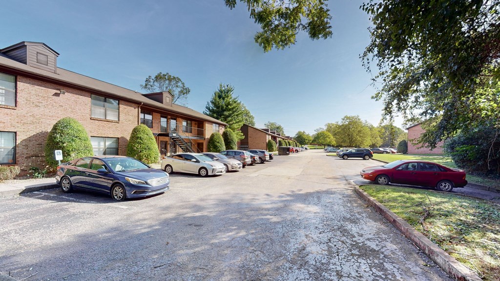a parking lot with cars parked in front of a building