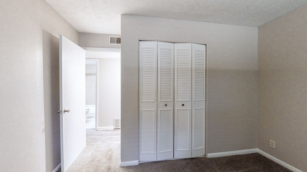 an empty room with white closet doors in it