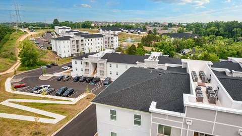 an aerial view of a building with cars parked in a parking lot