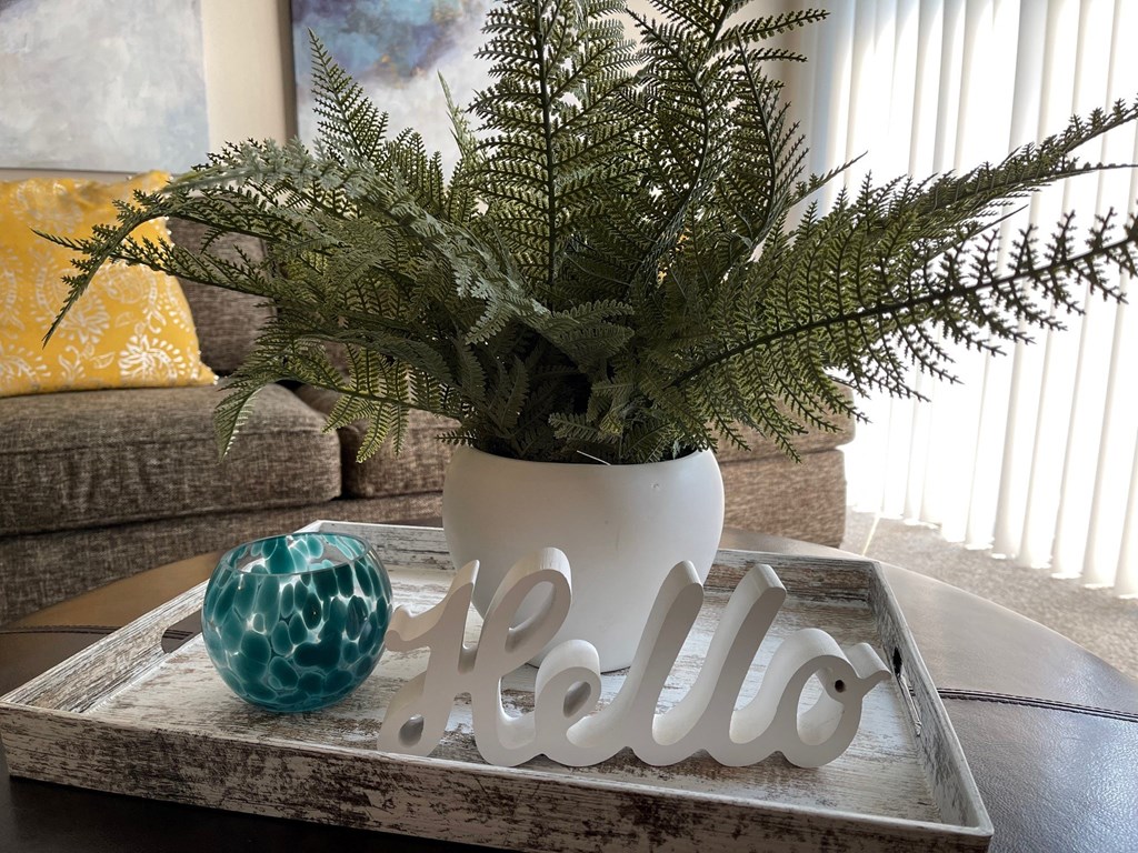 a vase with a plant on a tray on a table