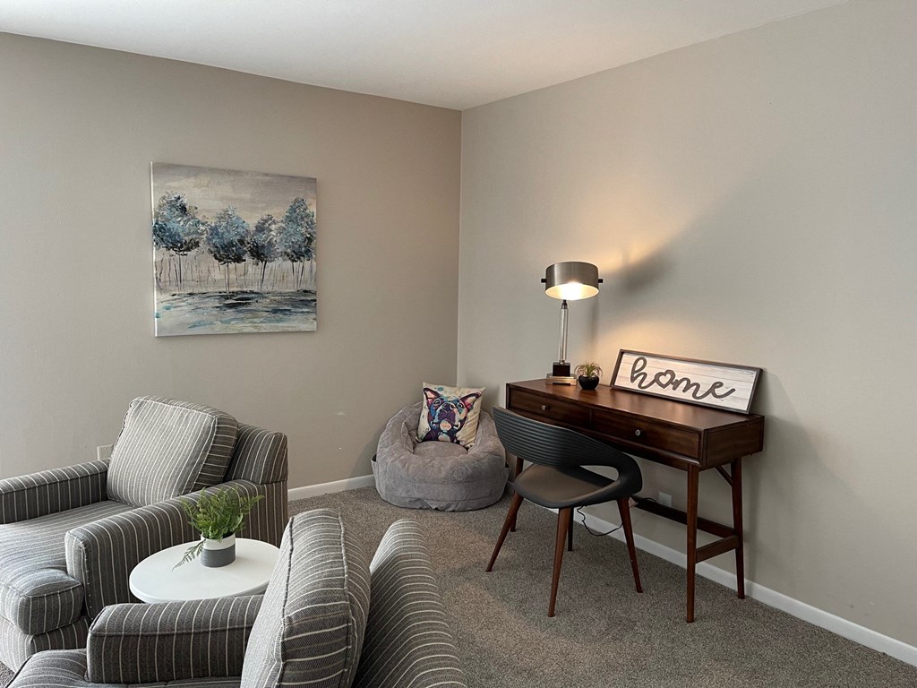 a living room with a desk and a couch