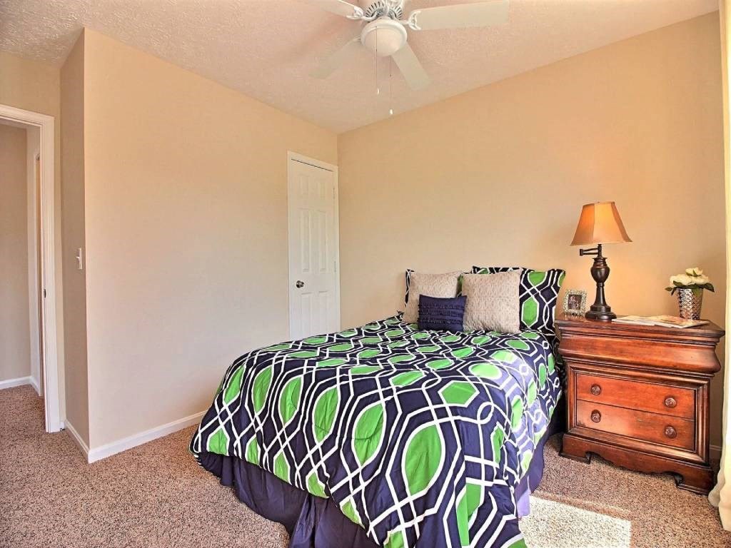 a bedroom with a bed and a ceiling fan