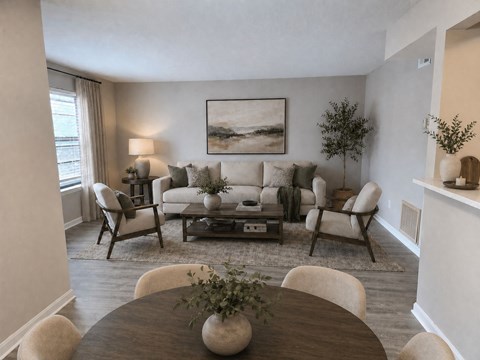 A living room with a brown table and white chairs.
