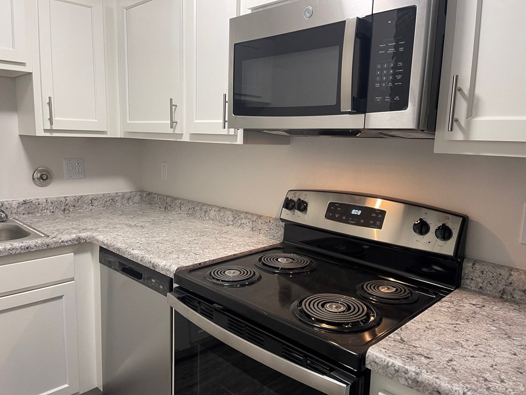 a kitchen with white cabinets and a black stove top oven