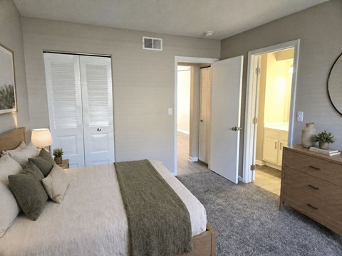 A bedroom with a bed, dresser, and mirror.