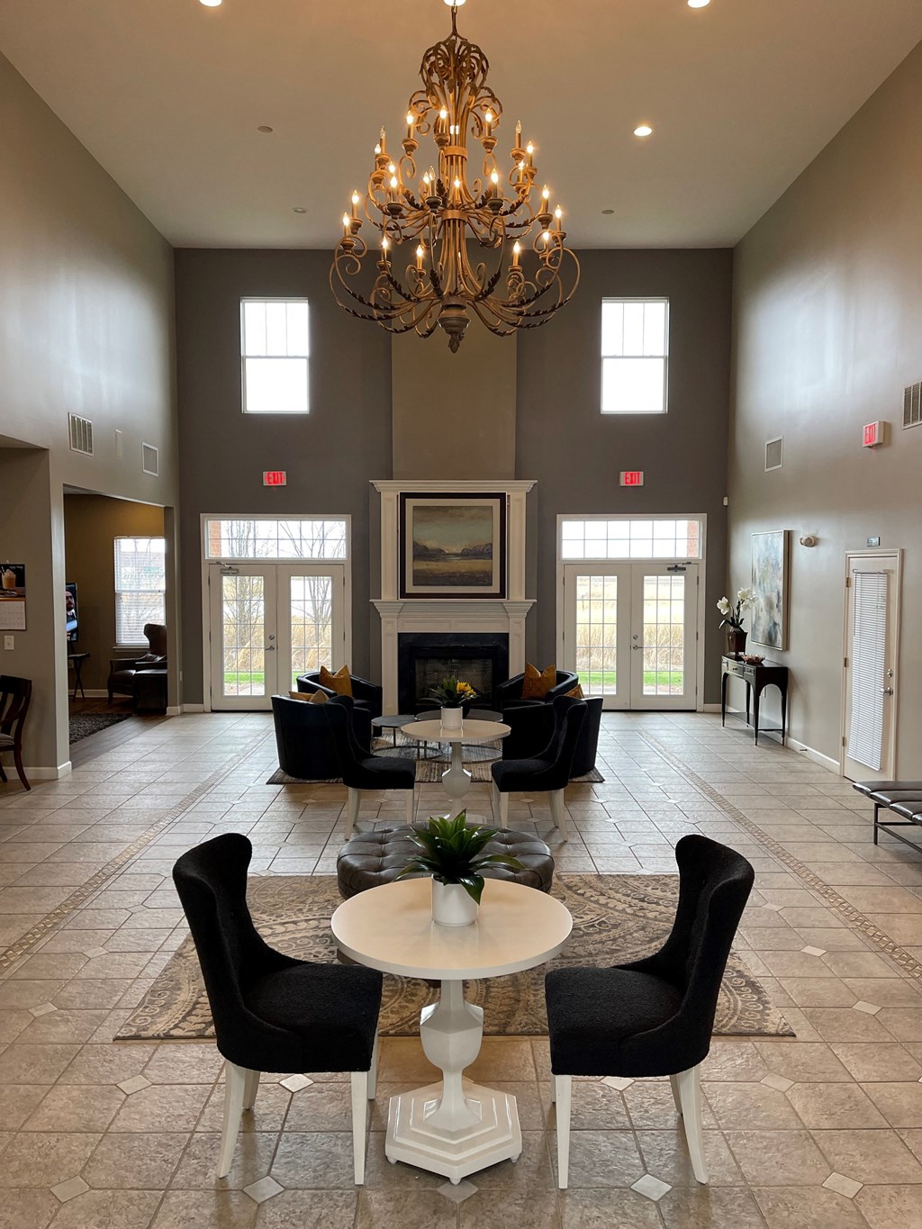 a large living room with a chandelier and tables and chairs