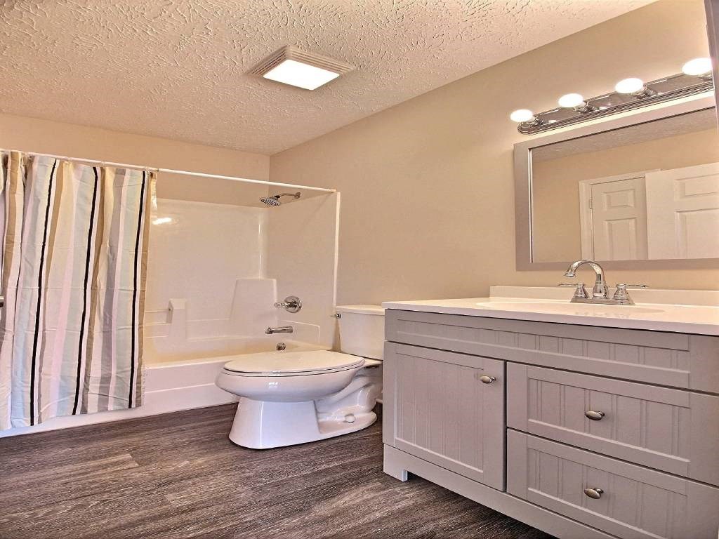 a bathroom with a toilet and a sink and a shower