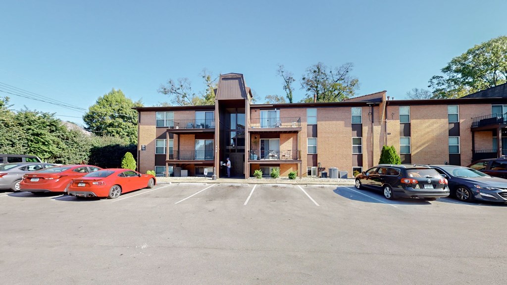 A parking lot with cars and a building in the background.