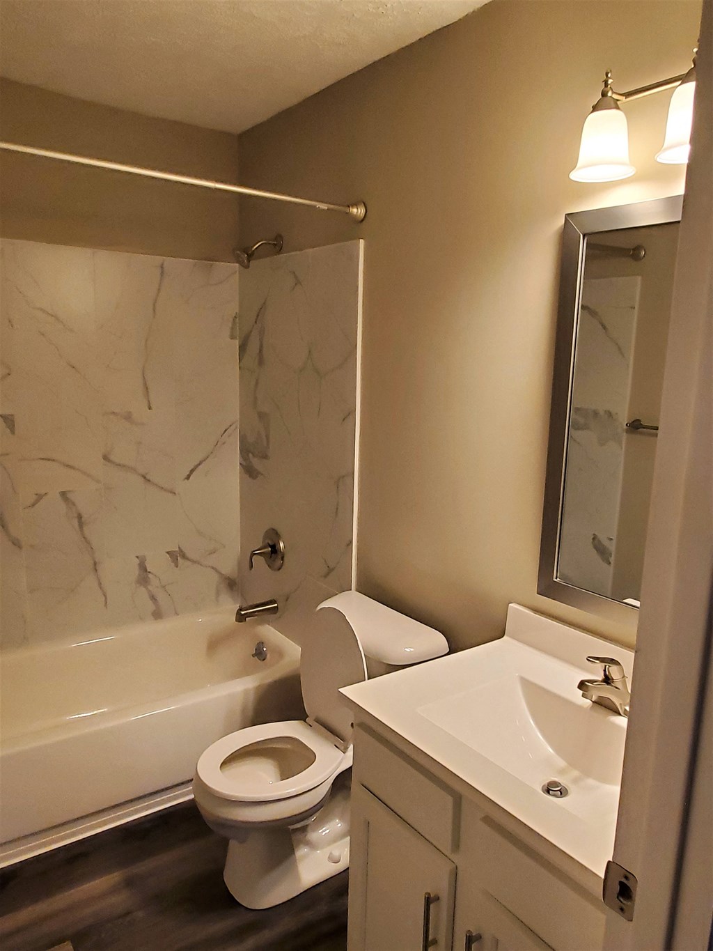 A white toilet sits next to a white sink in a bathroom.