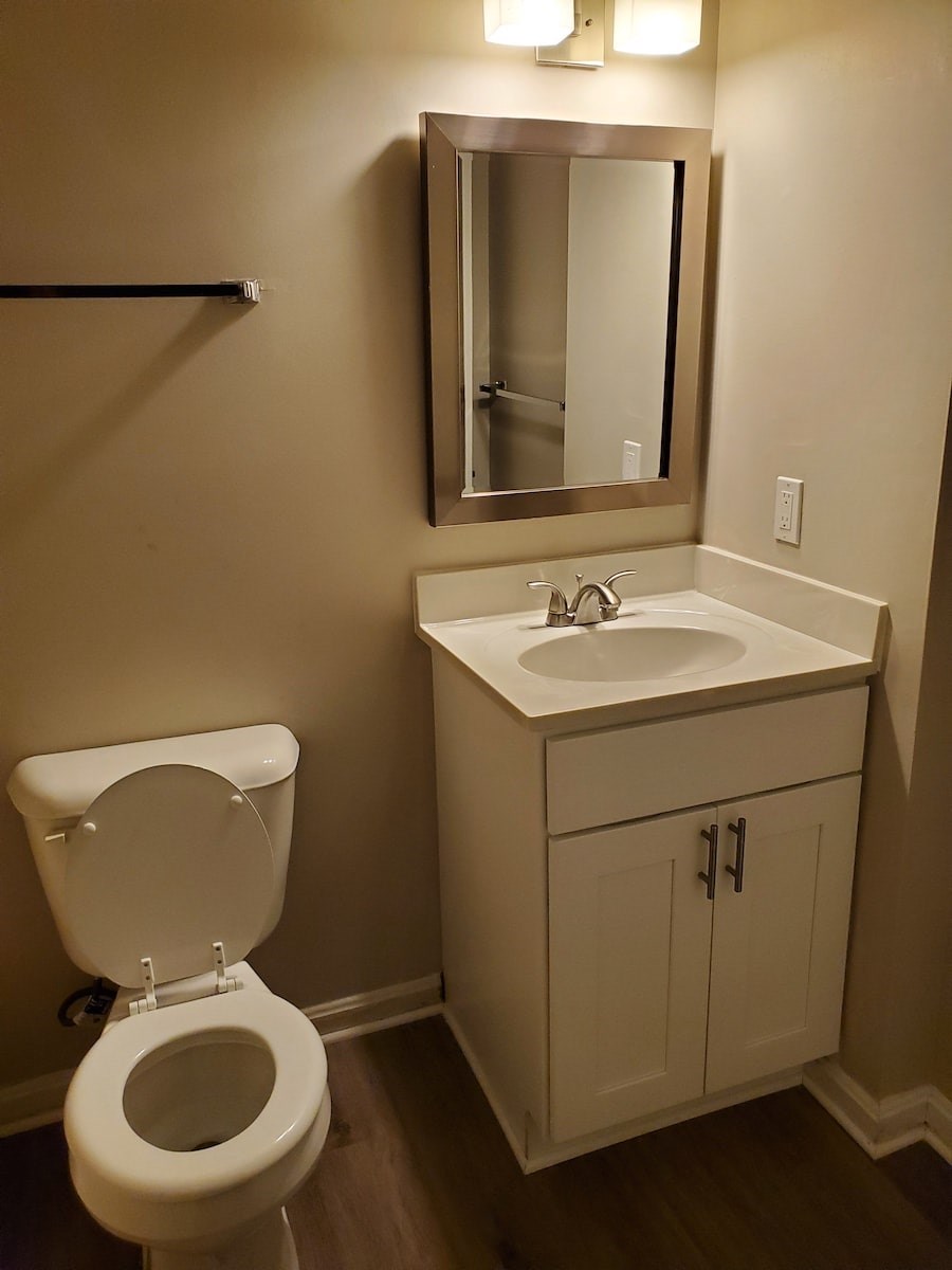 A white toilet sits next to a sink in a bathroom.